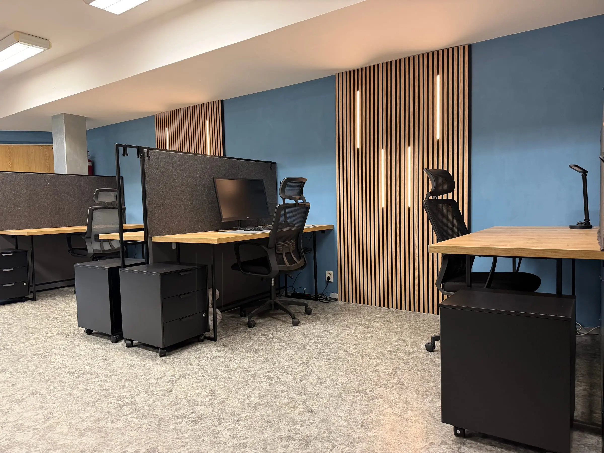 Pevná pracovní místa s monitorem, paravány a podsvícenou lamelovou stěnou